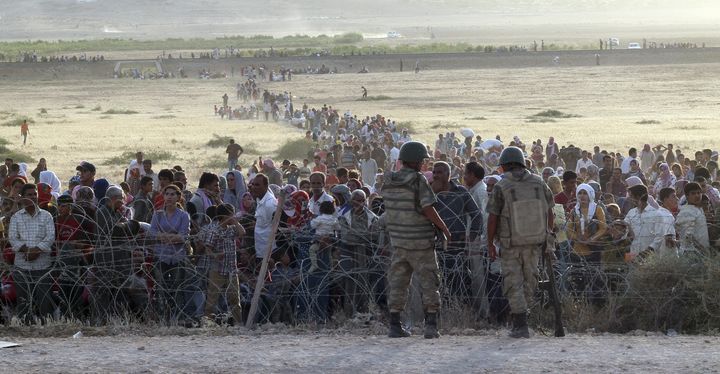 Des r&eacute;fugi&eacute;s kurdes de Kobani attendent l'autorisation d'entrer en Turquie, le 18 septembre 2014 pr&egrave;s de la ville de Suruc (Turquie). (REUTERS)