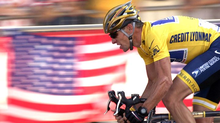 Lance Armstrong passe devant un drapeau am&eacute;ricain, sur le parcours du Tour de France, le 25 juillet 2004 sur les Champs-Elys&eacute;es, &agrave; Paris. (FRANCK PREVEL / AP / SIPA / AP)