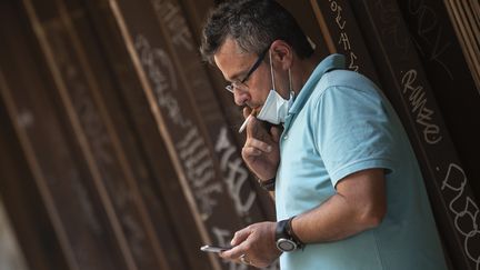 Un homme fume une cigarette dans une rue de Valence, le 13 août 2020, en Espagne. (JOSE JORDAN / AFP)