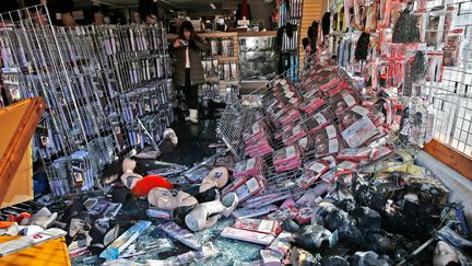 Une femme observe les d&eacute;g&acirc;ts dans un commerce de Ferguson, o&ugrave; la nuit a &eacute;galement &eacute;t&eacute; marqu&eacute;e par des pillages. (JIM YOUNG / REUTERS)