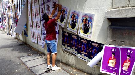 Le comédien Franck Nouzies accroche les affiches de son spectacle, "Les monologues de Feydeau", à Avignon, le 6 juillet 2021. (JEREMIE LAURENT-KAYSEN)