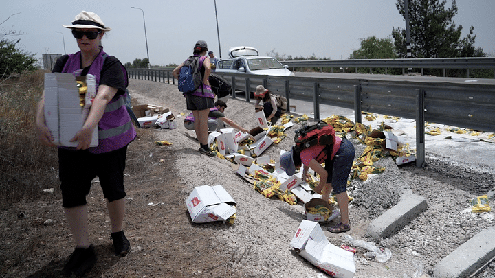 Les militants de "Standing Together" récupèrent les sacs de nourriture destinés à Gaza et arrachés du camion, en mai 2024. (SHARON ARONOWICZ / RADIOFRANCE)