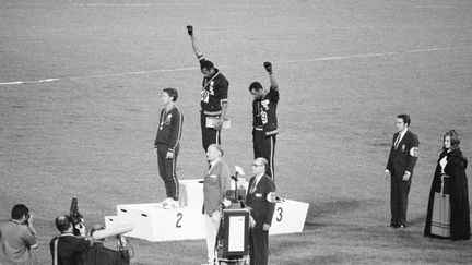 Tommie Smith (au centre) et John Carlos (à droite), les poings levés lors de la cérémonie de remise de médailles du 200 m aux Jeux de Mexico en 1968. (BETTMANN / BETTMANN)