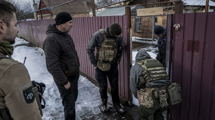 Un groupe de volontaires tentent de convaincre un habitant d'évacuer Bakhmout (Ukraine), le 20 février 2023. (MAREK M. BEREZOWSKI / ANADOLU AGENCY / AFP)