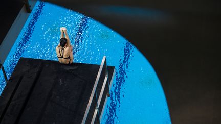 Un membre de l'équipe nationale chinoise de plongeon s'entraîne sur un plongeoir de 5 mètres à Shangai, en Chine, le 20 janvier 2016. (JOHANNES EISELE / AFP)