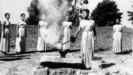 L'actrice grecque Aleca Katseli allume la flamme olympique qui sera transportée à Tokyo pour les Jeux Olympiques de 1964, à Olympie, en Grèce.  (GETTY IMAGES)