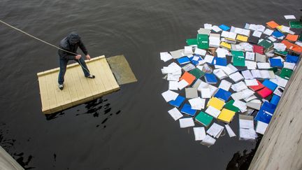 Un membre de l'opposition r&eacute;cup&eacute;rant des documents flottant dans le lac de la r&eacute;sidence pr&eacute;sidentielle pr&egrave;s de Kiev (Ukraine), le 22 f&eacute;vrier 2014. (ANDREY STENIN / RIA NOVOSTI / AFP)