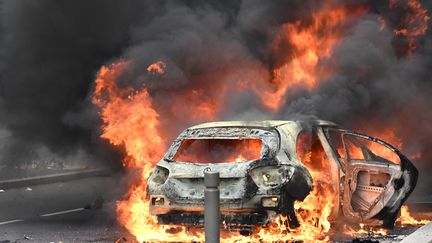 Une voiture brûlant à Nanterre le 29 juin 2023, deux jours après la mort de Nahel dans un contrôle de police. (BERTRAND GUAY / AFP)