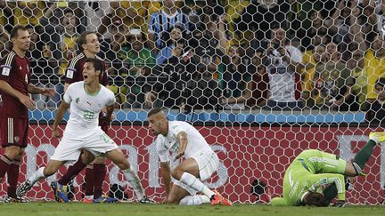 Islam Slimani (au centre, à genou) vient d'égaliser. Son coéquipier Aissa Mand exulte : l'Algérie est qualifiée (ADRIAN DENNIS / AFP)