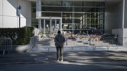 Un passant se recueille devant le commissariat de Rambouillet (Yvelines), le 26 avril 2021, après l'attaque ayant visé une fonctionnaire de police. (MAGALI COHEN / HANS LUCAS / AFP)