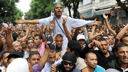 Des manifestants devant le siège de la chaîne de télévision Nessma TV, à Tunis, le 14 octobre 2011. (FETHI BELAID / AFP)