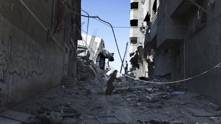 Une Palestinienne court pour tenter de se mettre &agrave; l'abri des bombes &agrave; Gaza, le 27 juillet 2014.&nbsp; (FINBARR O'REILLY / REUTERS)