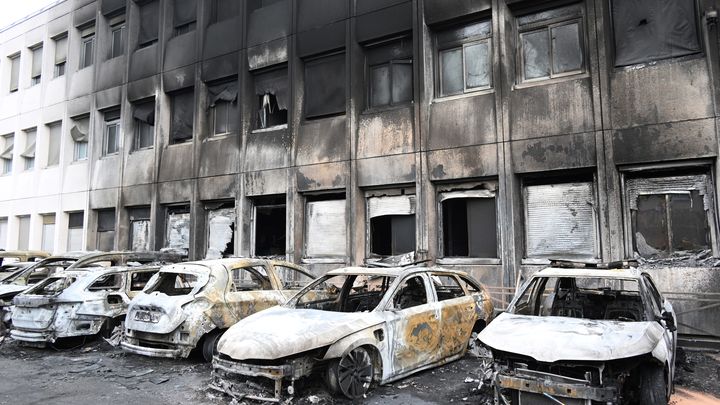 Des voitures brûlées devant les locaux de la police municipale incendiés le 29 juin 2023 à Neuilly-sur-Marne. (BERTRAND GUAY / AFP)