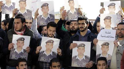 Des manifestant tiennent le portrait du pilote jordanien&nbsp;Maaz Al-Kassasbeh, le 3 janvier 2014. (KHALIL MAZRAAWI / AFP)