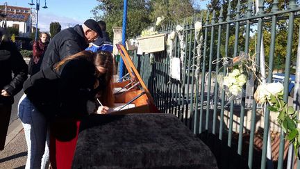 Des personnes signent&nbsp;le registre de condoléance à&nbsp;Saint-Féliu-D’avall. (JEROME JADOT / RADIO FRANCE)