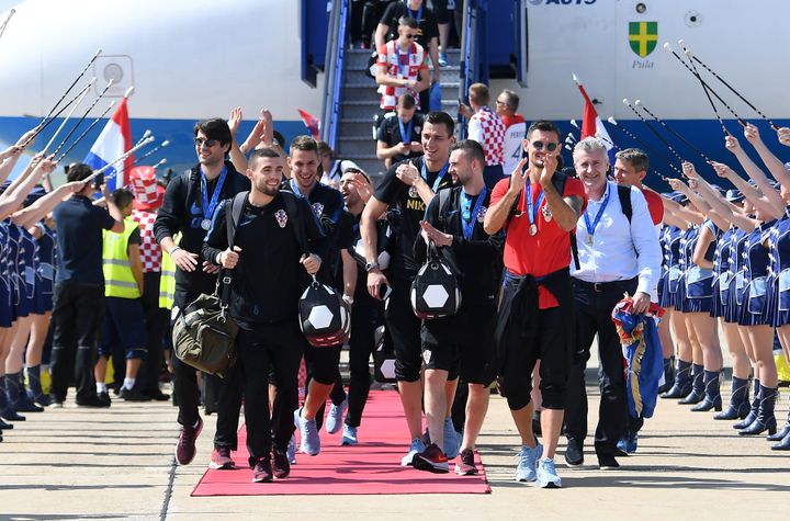 Les joueurs lors de leur retour sur le sol croate, lundi 16 juillet, à l'aéroport de Zagreb. (ATTILA KISBENEDEK / AFP)