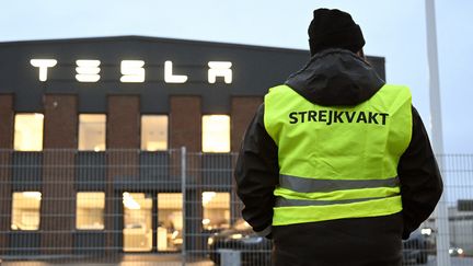 Une ouvrière fait le piquet de grève devant un centre Tesla en Suède. (JESSICA GOW / MAXPPP)