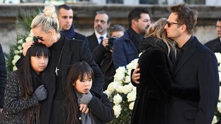 A gauche, Laeticia, Jade et Joy Hallyday ; à droite, David Hallyday et Laura Smet, aux obsèques de Johnny Hallyday, à la Madeleine, à Paris, le 9 décembre 2017. (LUDOVIC MARIN / AFP)