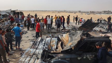 Des Palestiniens sur le site d'une frappe israélienne contre un camp de personnes déplacées à Rafah, le 27 mai 2024. (EYAD BABA / AFP)