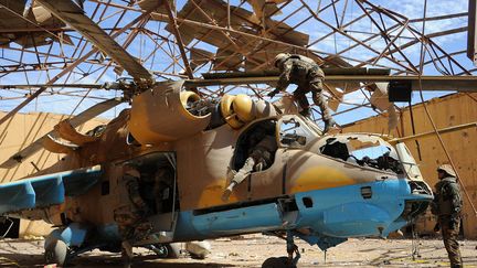 Des d&eacute;mineurs de l'arm&eacute;e fran&ccedil;aise inspectent un h&eacute;licopt&egrave;re dans un hangar &agrave; l'a&eacute;roport de Gao (Mali), le 9 f&eacute;vrier 2013. (PASCAL GUYOT / AFP)