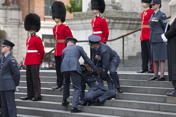 Un membre de la Royal Air Force s'écroule dans les escaliers de la cathédrale Saint-Paul, le 10 juin 2016, à Londres (Angleterre).&nbsp; (JUSTIN TALLIS / AFP)