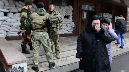 Des soldats et des proches des mineurs tu&eacute;s lors d'une explosion survenue dans une mine de l'est de l'Ukraine, &agrave;&nbsp;Zassiadko, le 4 mars 2015. (JOHN MACDOUGALL / AFP)