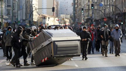 Des manifestants renversent une poubelle dans le centre-ville de Burgos (Espagne), le 29 mars 2012. (CESAR MANSO / AFP)