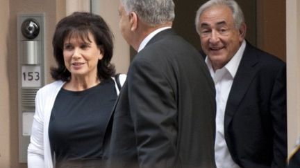 Dominique Strauss-Kahn et son épouse Anne Sinclair, souriants, quittant leur domicile après la séance au tribunal (AFP - DON EMMERT)