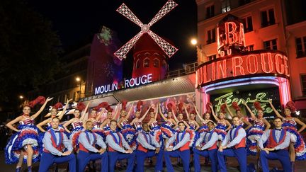 Les équipes du cabaret ont investi la place Blanche, juste devant l'établissement, pour immortaliser l'événement et offrir un spectacle surprise aux passants. (BERTRAND GUAY / AFP)