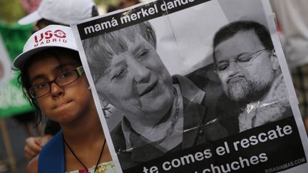 Une jeune tient une affiche qui d&eacute;nonce la politique europ&eacute;enne &agrave; Madrid jeudi 19 juillet. (SUSANA VERA / REUTERS)