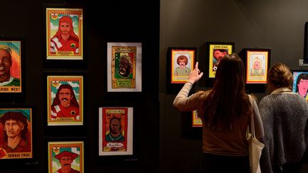 Des visiteurs devant des portraits de footballeurs à l'expo Haircut FC à Aix-en-Provence.
 (Christophe SIMON / AFP)