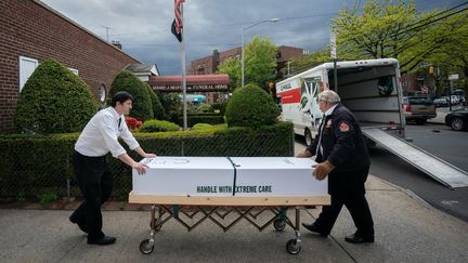 Un cercueil est chargé dans un camion du salon funéraire Gerard J. Neufeld pour être incinéré dans le quartier du Queens, à New York, le 11 mai 2020. (BRIAN SMITH / SPUTNIK / AFP)