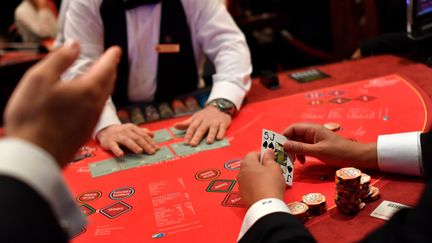 Un croupier face à des joueurs, dans un casino (image d'illustration). (LOIC VENANCE / AFP)