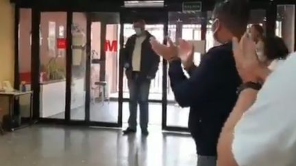 Capture d'écran de la vidéo postée le 18 avril 2020 sur Twitter, où l'on voit un chauffeur de taxi applaudi par des soignants du centre&nbsp;de santé Ramon y Cajal à Madrid. (ELTAXIUNIDO / TWITTER)