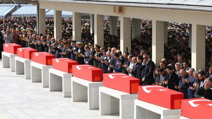 Le premier ministre turc Ahmet Davutoglu (au centre) prie devant les cercueils des victimes de l'attaque à la voiture piégée d'Ankara (Turquie), jeudi 19 février 2016. (ADEM ALTAN / AFP)