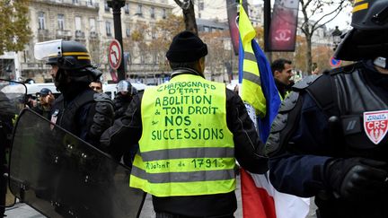 La colère des "gilets jaunes" cible de nombreuses taxes. Cet homme réclame par exemple le fin des droits de succession acquittés à l'Etat, le 24 novembre 2018 sur les Champs-Elysées. "Il&nbsp;ne s’agit en aucun cas de revoir la fiscalité des droits de succession", a répondu le secrétaire d'Etat Gabriel Attal, dans un entretien au "Monde". (BERTRAND GUAY / AFP)