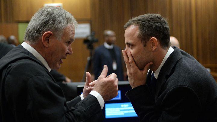 Oscar Pistorius (à droite) avec son avocat Barry Roux (à gauche), lors du premier jour de son procès, le 3 mars 2014, devant la Haute cour de Pretoria. (ANTOINE DE RAS / AFP)