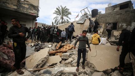 Palestinians amid the damage caused by an Israeli bombardment in Gaza, February 18, 2024. (MAJDI FATHI / AFP)