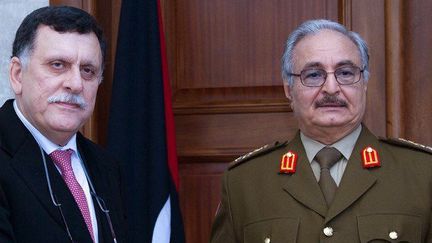 La poignée de mains entre Fayez Sarraj, président du conseil libyen, et le Maréchal Khalifa Haftar, commandant de l'Armée nationale libyenne, le 31 janvier 2016, dans la localité d'Al-Marj située à 80 km de la ville portuaire de Benghazi.  ( STRINGER/LIBYAN ARMED FORCES MEDIA OFFICE/AFP)