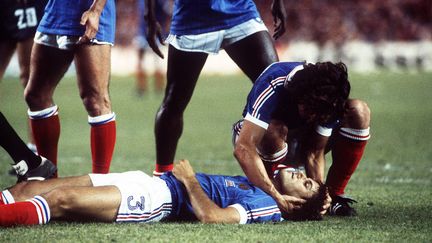 Patrick Battiston&nbsp;g&icirc;t, inconscient, apr&egrave;s un choc avec le gardien allemand Harald Schumacher, le 8 juillet 1982, &agrave; S&eacute;ville (Espagne), lors de la Coupe du monde. (SVEN SIMON / PICTURE ALLIANCE / AFP)