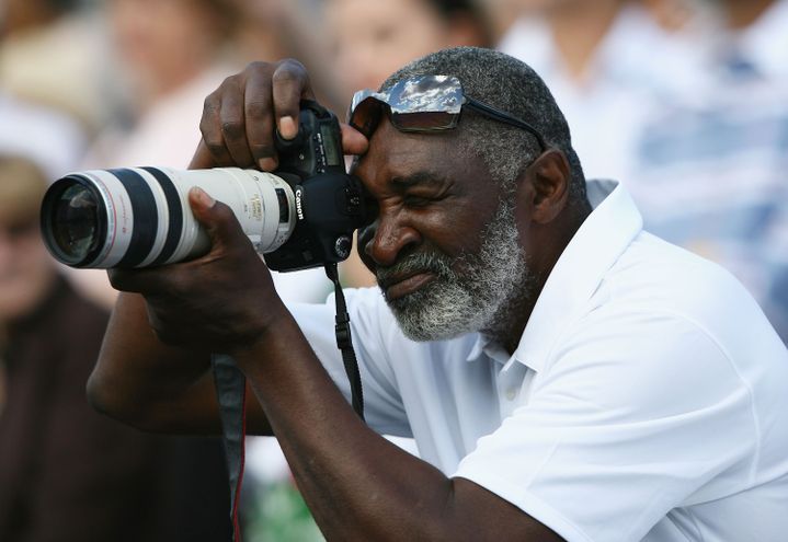 Le p&egrave;re de Venus et Serena Williams prend une photo sur le bord du court &agrave; Wimbledon, pendant le match de Venus contre Marion Bartoli, le 7 juillet 2007. (CLIVE BRUNSKILL / GETTY IMAGES)