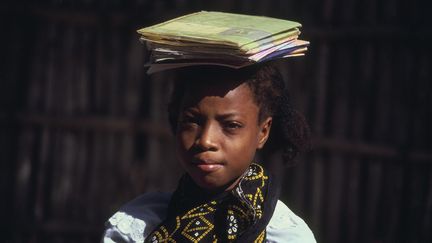 Fillette de Mayotte qui porte ses cahiers d'école.&nbsp; (GETTY IMAGES)