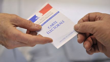 Un électeur présente sa carte électorale le 14 mars 2010. (THIERRY ZOCCOLAN / AFP)