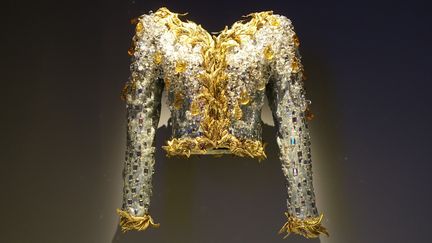 La haute couture fait appel aux savoirs de métiers tels que les tisserands, teinturiers, imprimeurs, brodeurs, plumassiers et orfèvres.... Véritables chef d'oeuvres, ces pièces témoignent de savoirs ancestraux pour des créations élaborées qui nécessitent des centaines d'heures de travail. Cette veste, installée toute seule dans un espace cloisonné, parle d'elle-même. 
 (Corinne Jeammet)