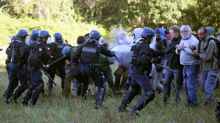 Des CRS entourant des opposants au barrage de Sivens, pr&egrave;s de Lisle-sur-Tarn (Tarn), le 1er septembre 2014. (FLORINE GALEORN / AFP)