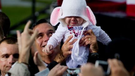 J-29 #TEAMROMNEY Le candidat r&eacute;publicain Mitt Romney brandit un b&eacute;b&eacute; lors d'un meeting politique &agrave; Newport&nbsp;News (Virginie), le 8 octobre 2012. (JIM WATSON / AFP)