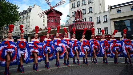 Les danseuses du Moulin rouge sur le Boulevard de Clichy pour annoncer la réouverture du cabaret en septembre, le 17 mai 2021 (MARTIN BUREAU / AFP)