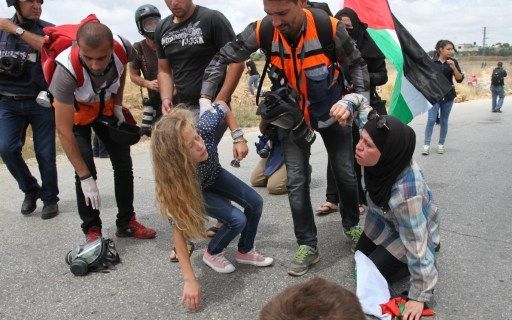 6 juin 2014. A Ramallah, Cisjordanie, des secouristes viennent en aide à une manifestante et sa fille, lors d'une manifestation de soutien aux détenus palestiniens en grève de la faim dans les prisons israéliennes.  (ABDALKARIM MUSEITEF/AFP)