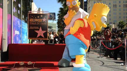 Bart (D) et Homer Simpson inaugurent leur &eacute;toile sur le Hollywood Walk of Fame (Californie), le 14 f&eacute;vrier 2012. (ROBYN BECK / AFP)