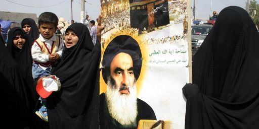 Femmes chiites tenant un portrait du grand aytollah Ali Sistani à Najaf (160 km au sud de Bagdad) le 14-4-2006. Ali Sistani est le dignitaire chiite le plus vénéré en Irak. (AFP - QASSEM ZEIN)